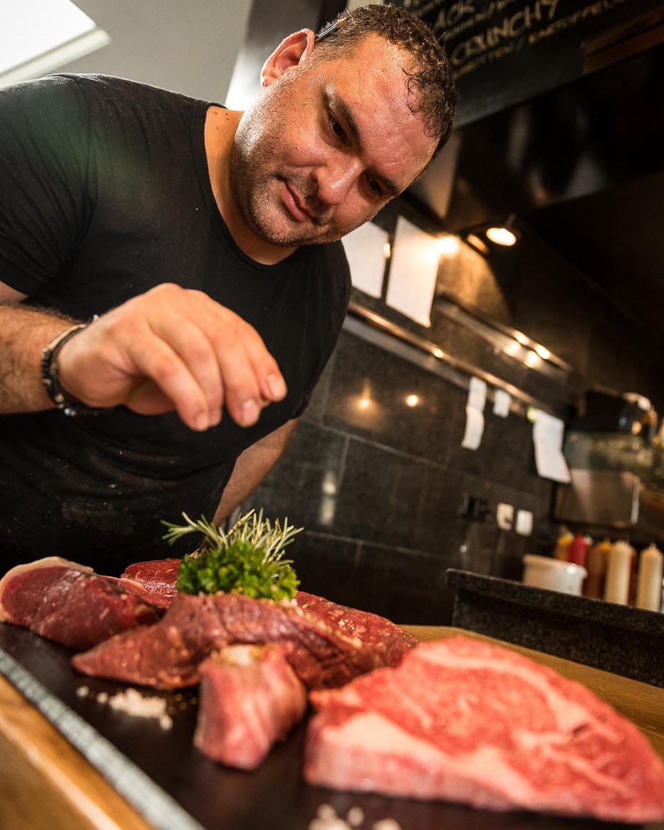 Marco Lizzio präsentiert frisches Steak auf Schneidebrett.
